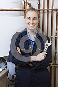 Female Plumber Working On Central Heating Boiler