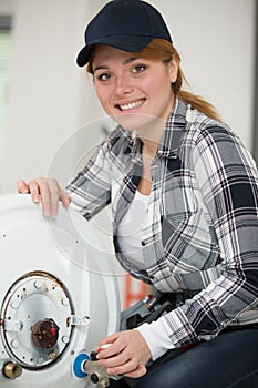 female plumber working on hot water boiler