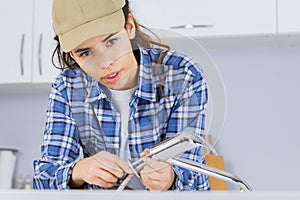 Female plumber working on sink