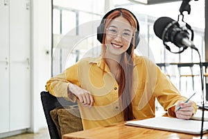 Female podcaster making audio podcast from her home studio