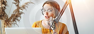 Female podcaster making audio stream in her small studio