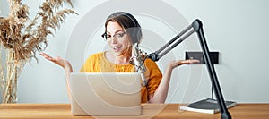 Female podcaster streaming her voice into mike at home studio