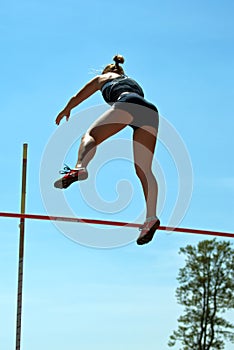 Female pole vaulter in mid-air