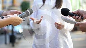 Female politician talking on media press conference, public relations, event photo