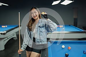 female pool player blink her eye while standing beside the pool