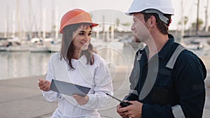 Female port control officer talking with seafarer