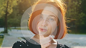 Female portrait outdoors in city dissatisfied redhead caucasian woman girl shakes index finger warns disapprovingly