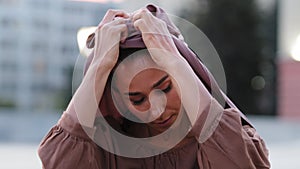 Female portrait outdoors sad face serious islamic muslim woman victim girl takes off headscarf hijab from head changes