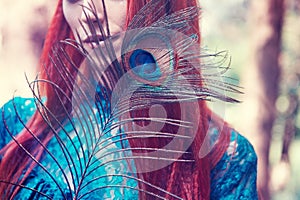 Female portrait with peacock feather on foreground. beauty makeup.