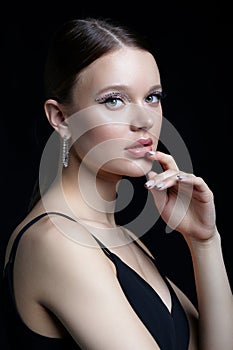 Female portrait with rhinestones makeup. Woman with earring in the form of a shiny ring in the ear