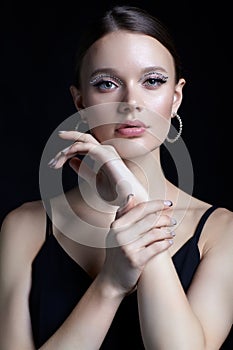 Female portrait with rhinestones makeup. Woman with earring in the form of a shiny ring in the ear