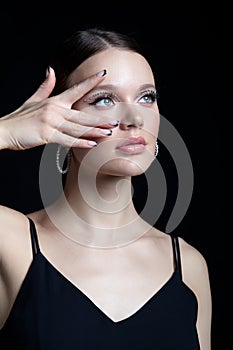 Female portrait with rhinestones makeup. Woman with earring in the form of a shiny ring in the ear