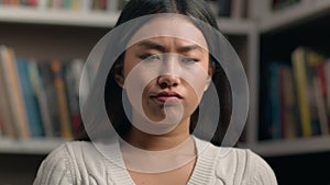 Female portrait upset sad asian woman student looking at camera with distressed frustrated expression in university