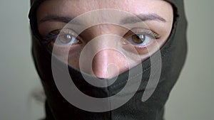 Female portrait of young girl wearing khaki balaclava, only eyes are visible, mandatory conscription, military, feminism