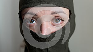 Female portrait of young girl wearing khaki balaclava, only eyes are visible, mandatory conscription, military, feminism