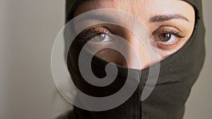 Female portrait of young girl wearing khaki balaclava, only eyes are visible, mandatory conscription, military, feminism