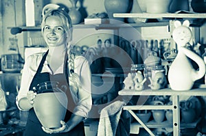 Female potter in apron in atelier