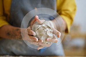 Female potter artist hands molding raw clay. Woman ceramist in apron prepare for shaping pottery