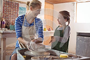 Female potter assisting girl