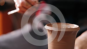 Female potter make clay pot on the pottery wheel. Close up shot of potter making ceramic pot on pottery wheel at