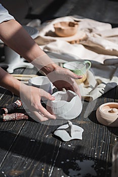 Female potter making ceramic dishes at her studio. Working process of glazing ceramic bowl.