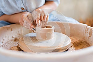 Female potter making a pot on pottery wheel