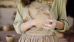 female potter sculpting clay pot with hands. Ceramist woman work with raw earthenware creating handmade pottery