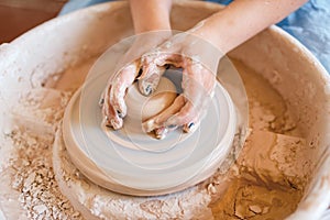 Female potter shaping a pot on pottery wheel