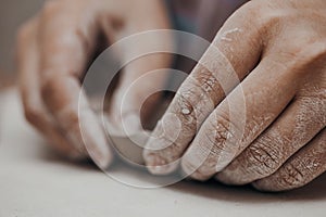 Female potter works with clay, craftsman hands close up, kneads and moistens the clay before work