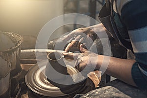 Female potter works with clay on pottery wheel, craftsman hands close up
