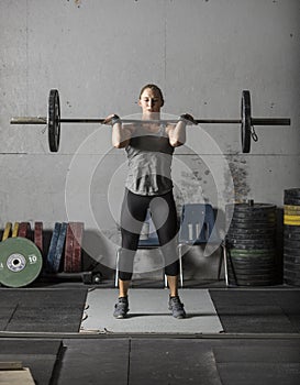 Female powerlifter doing a clean and jerk with heavy weights