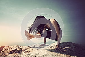Female practicing yoga arm-balance handstand