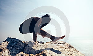 Female practicing yoga on seaside