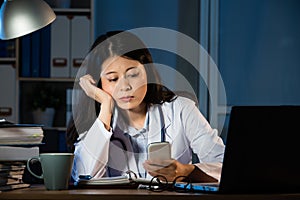 Female practitioner working in office using smartphone