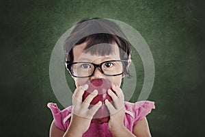 Female preschooler eats red apple