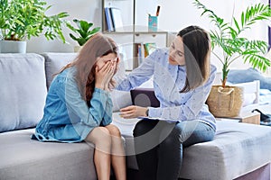 Female professional child psychologist working with preteen girl in office