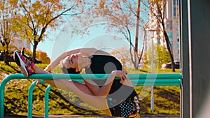 Female professional dancer performing choreographic exercises on parallel bars