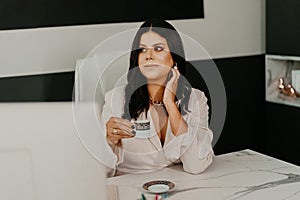 Female professional at her home office, smiling with contentment