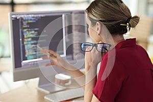 Female programmer checkups code working on computer
