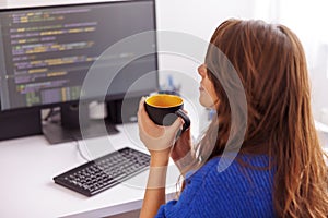 Female programmer taking coffee break while working remotely from home