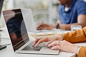 Female programmer typing codes on laptop