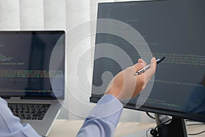 Female programmer working on a computer planning a program in an office. Notebook and troubleshooting program