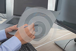 Female programmer working on a computer planning a program in an office. Notebook and troubleshooting program