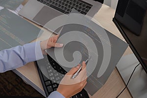 Female programmer working on a computer planning a program in an office. Notebook and troubleshooting program