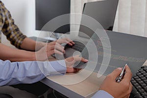 Female programmer working on a computer planning a program in an office. Notebook and troubleshooting program