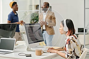 Female programmer writing codes on computer