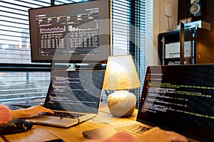 Female programmer writing programming code at cozy home workplace