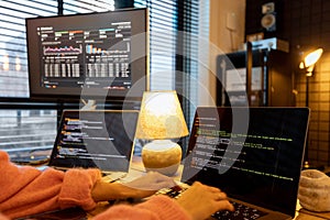 Female programmer writing programming code at cozy home workplace