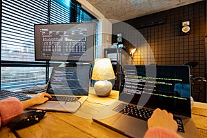 Female programmer writing programming code at cozy home workplace