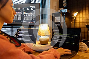 Female programmer writing programming code at cozy home workplace